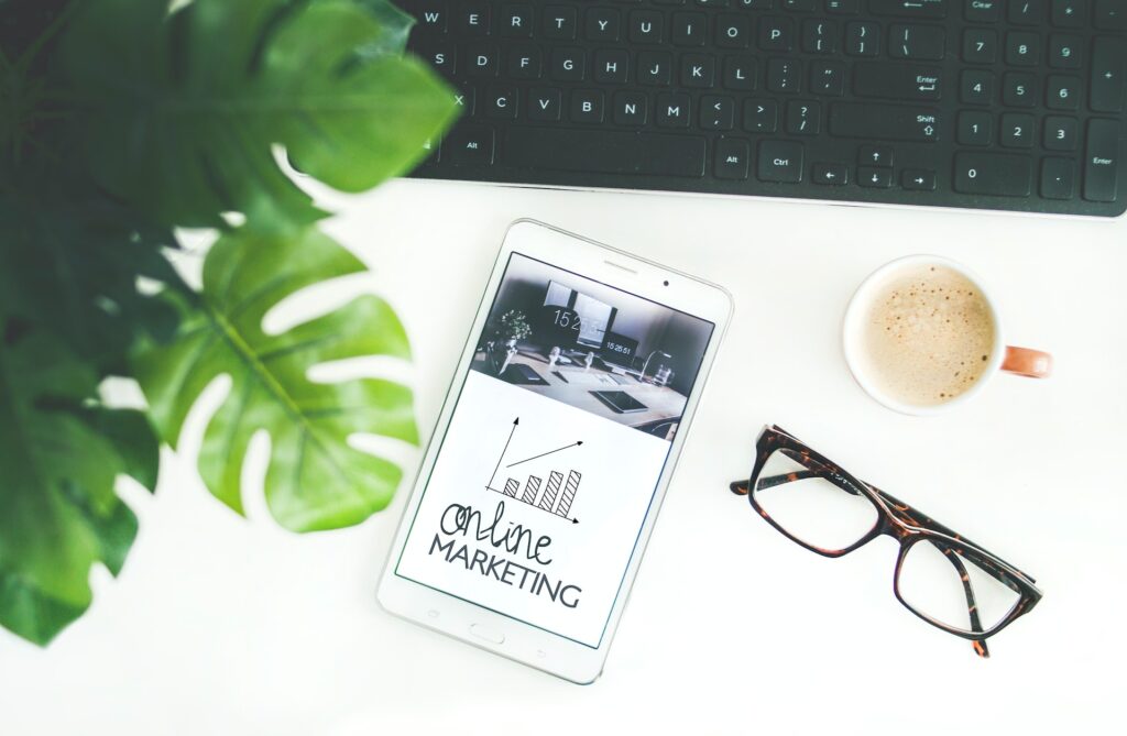 A tablet with the words online marketing on it, some glasses, and a coffee mug