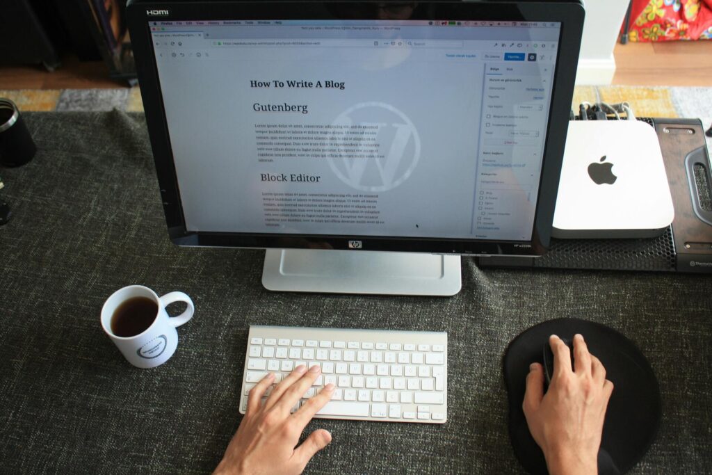 A person off-screen writing a blog on their Mac computer

