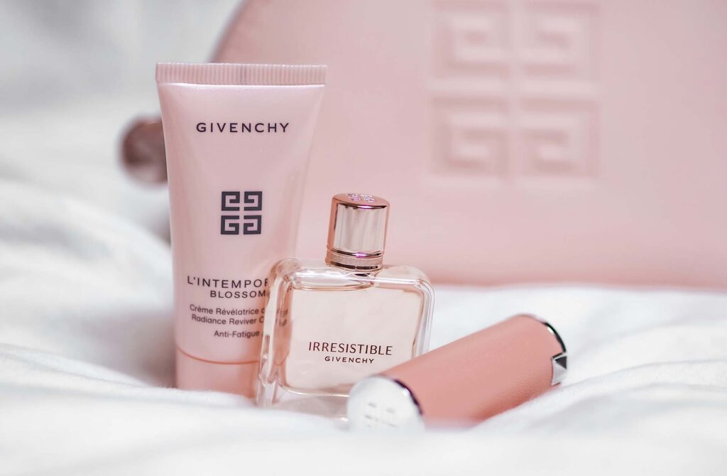 A perfume bottle and cosmetic products on a white sheet 